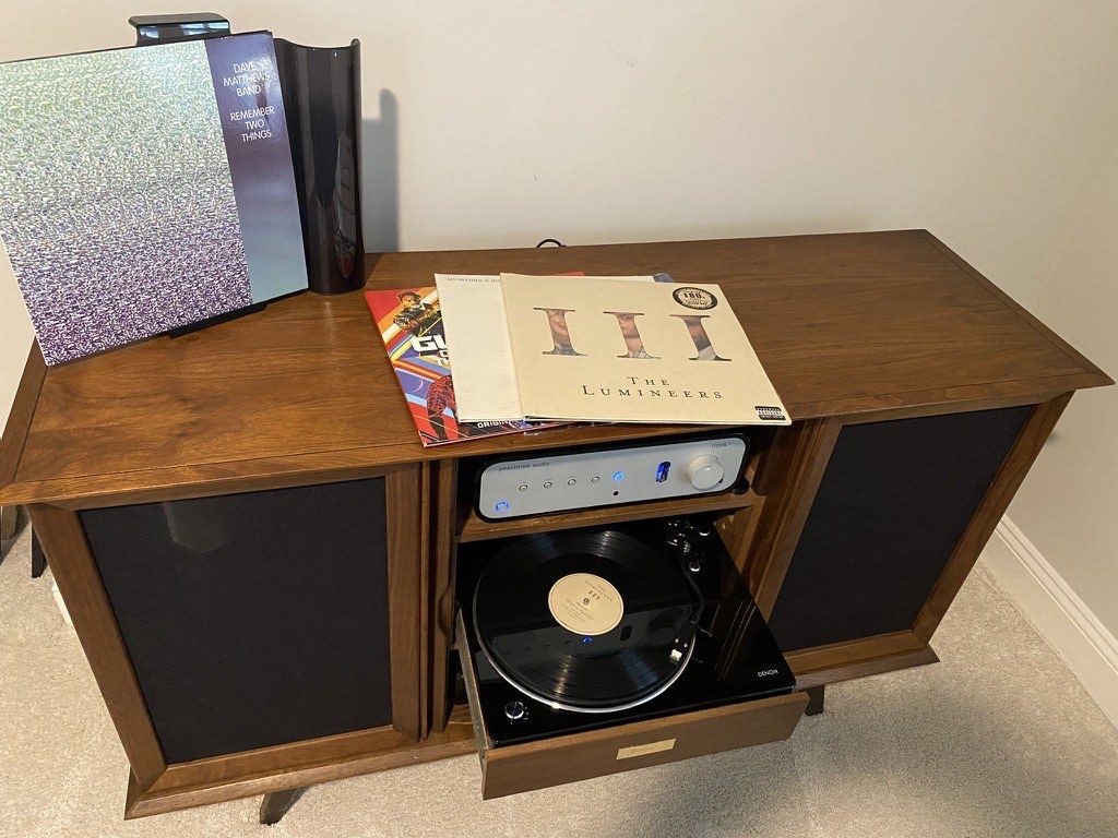 Restored stereo cabinet in the house with a modern turntable, amp, and gatefold records