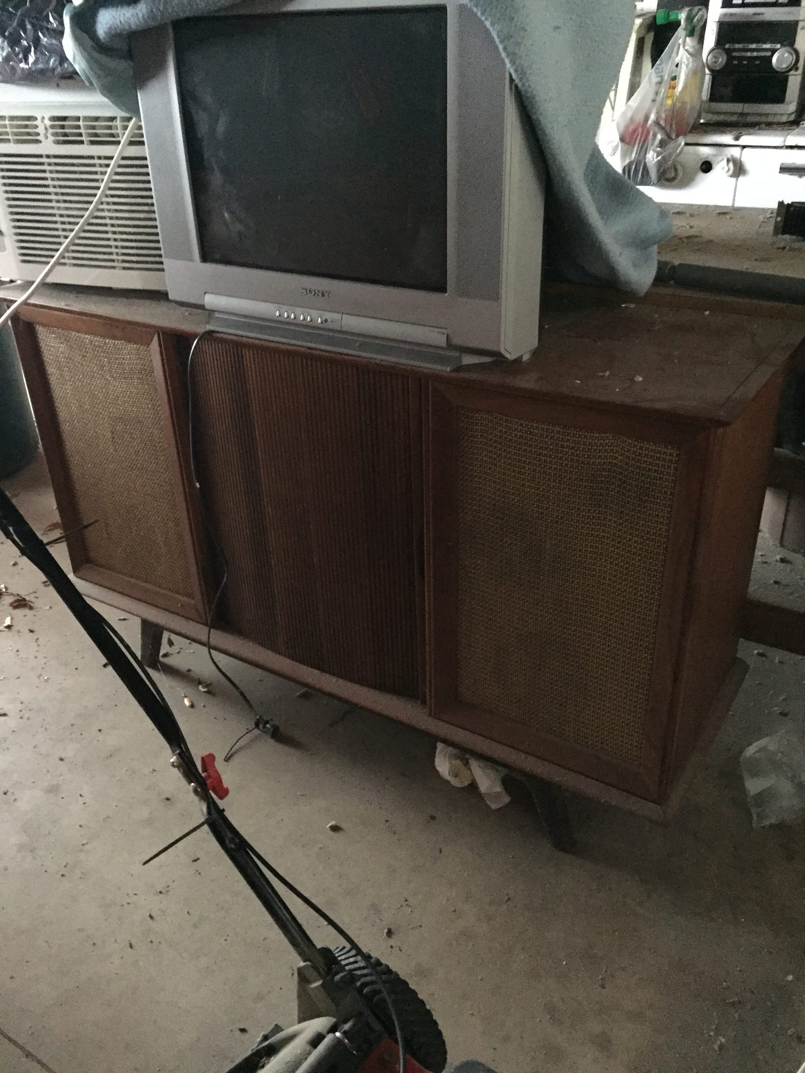 Grandfather’s stereo cabinet in the garage, dusty, with a CRT TV on top